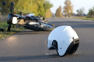 white motorcycle helmet on asphalt in front of overturned motorcycle